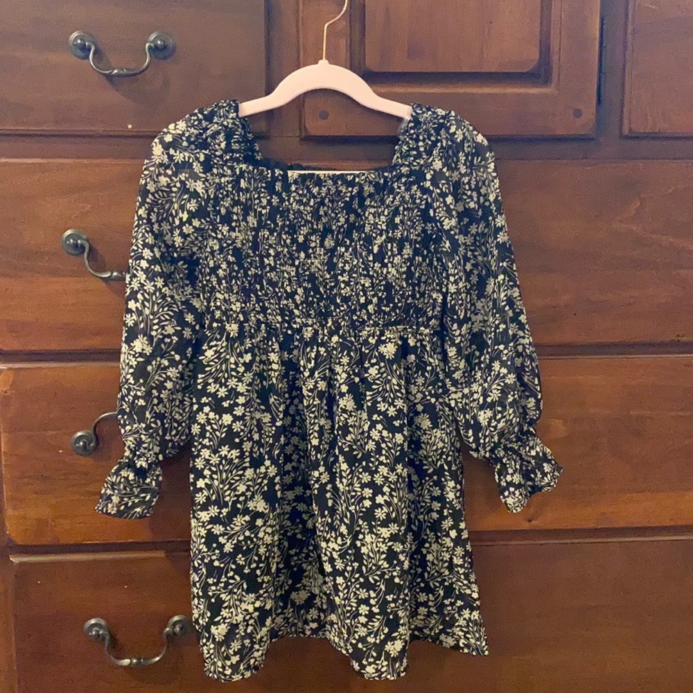 Black and cream (tan) flowers. Too is smocked and 100% polyester.